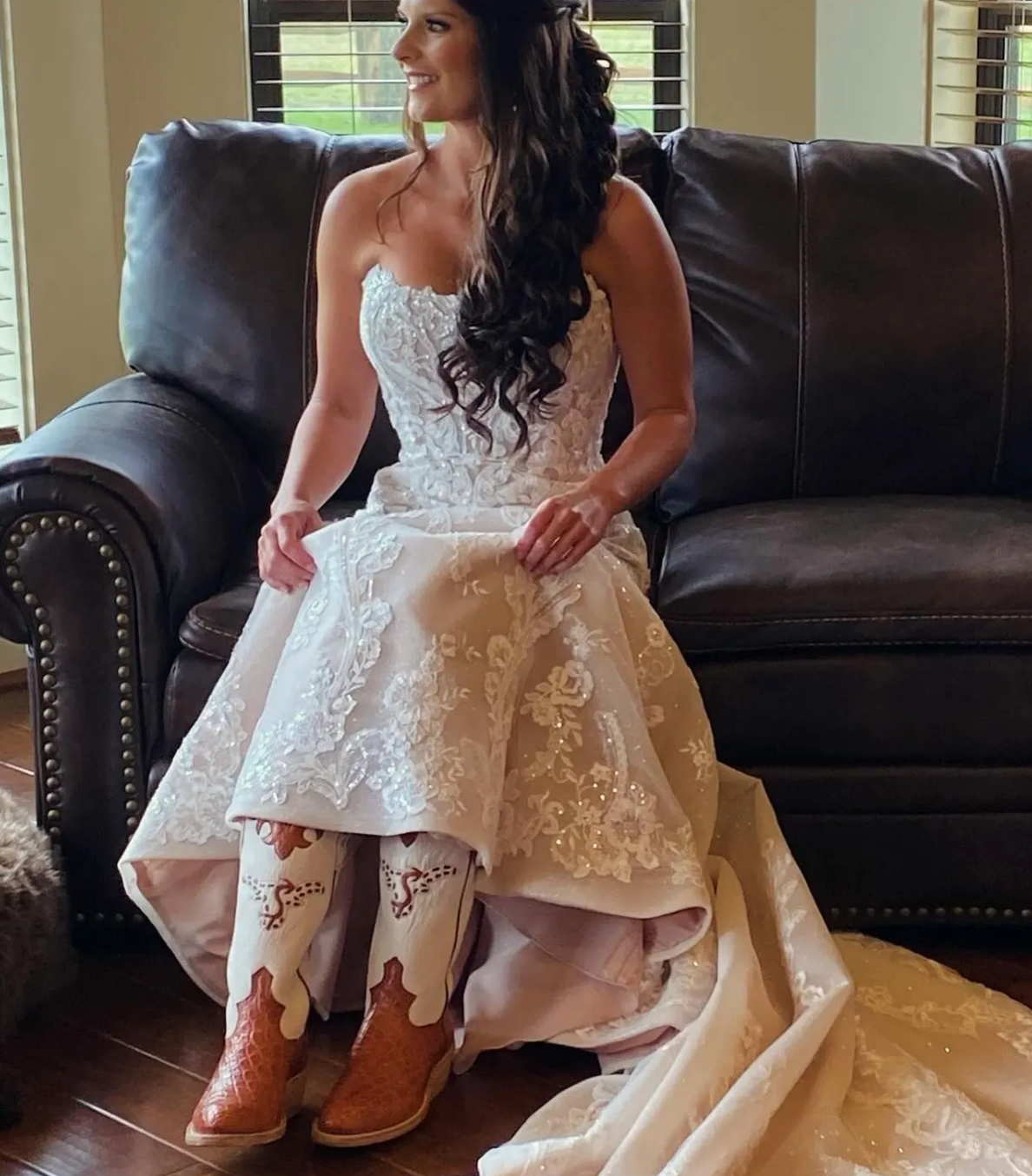 Bride showing her custom cream and brown cowboy boots beneath her wedding dress