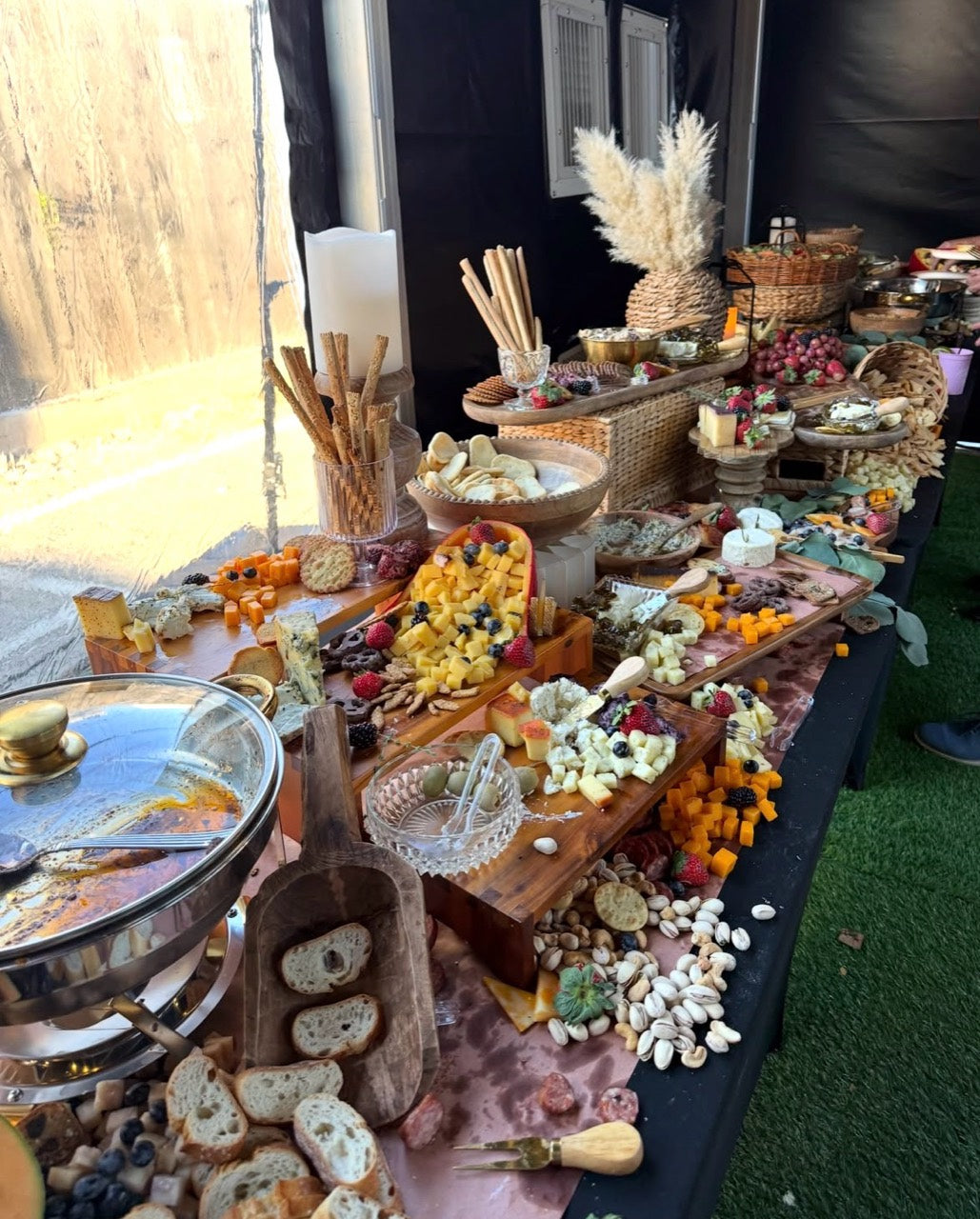 An abundant charcuterie spread with cheeses, fruit, breads and accompaniments