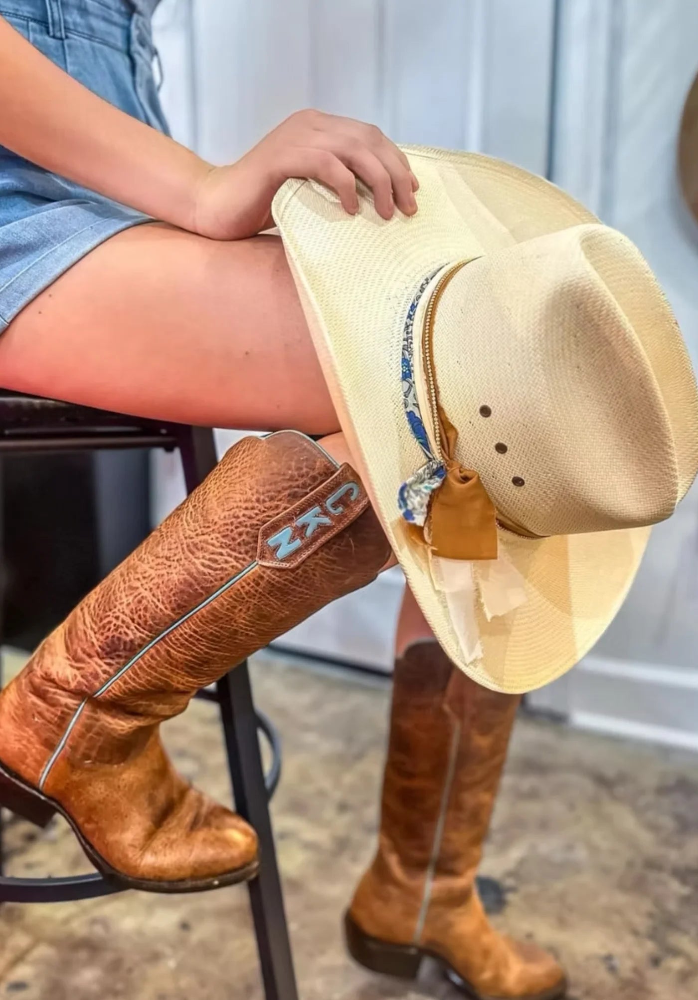 Straw hat styled with a patterned band and Western boots