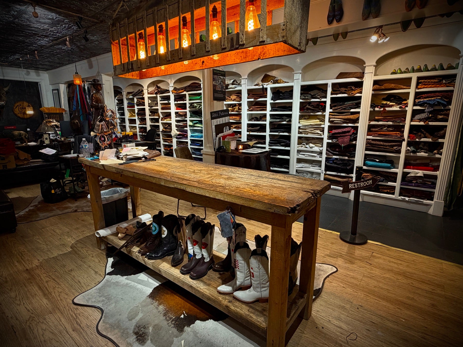 Design table, custom boots and walls of leather hides at Republic Boot Co. in Houston Heights