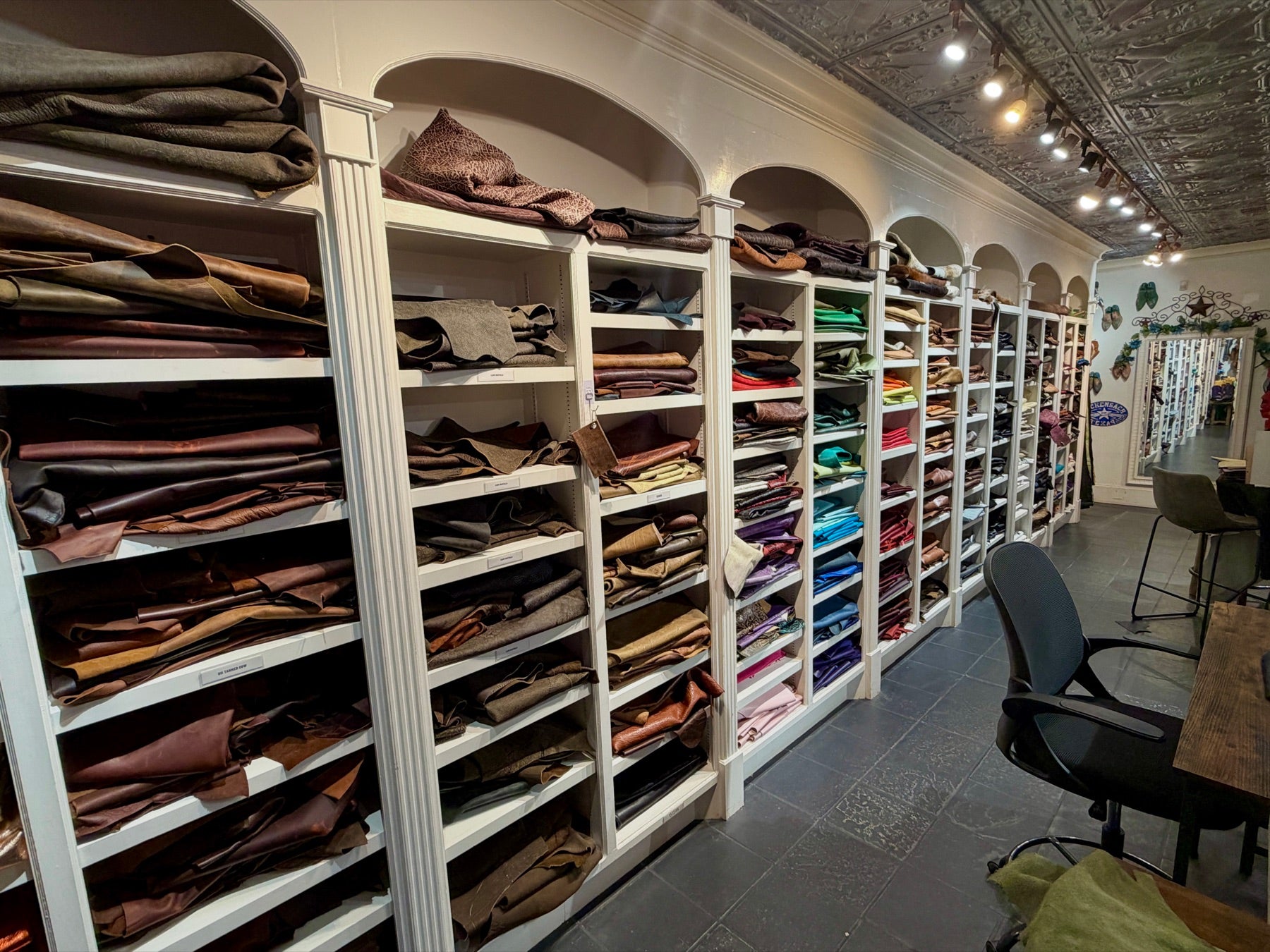Shelves of leather hides in many colors and textures in Republic’s Houston Heights custom boot room